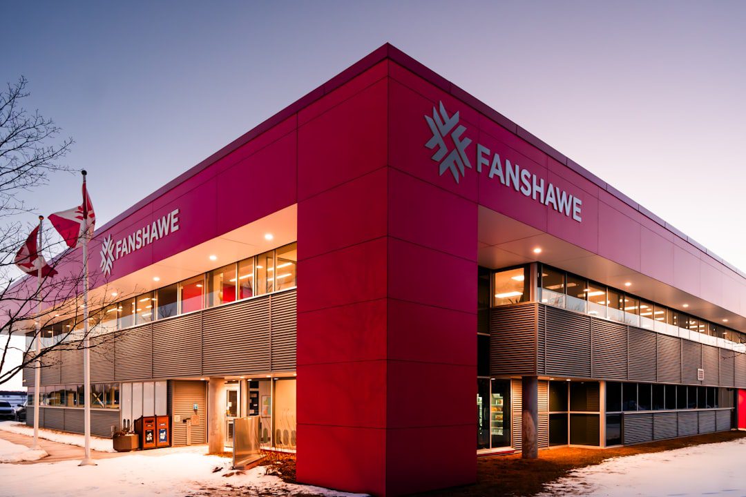 client communication skills — Modern building with red accents and fanshawe logo.