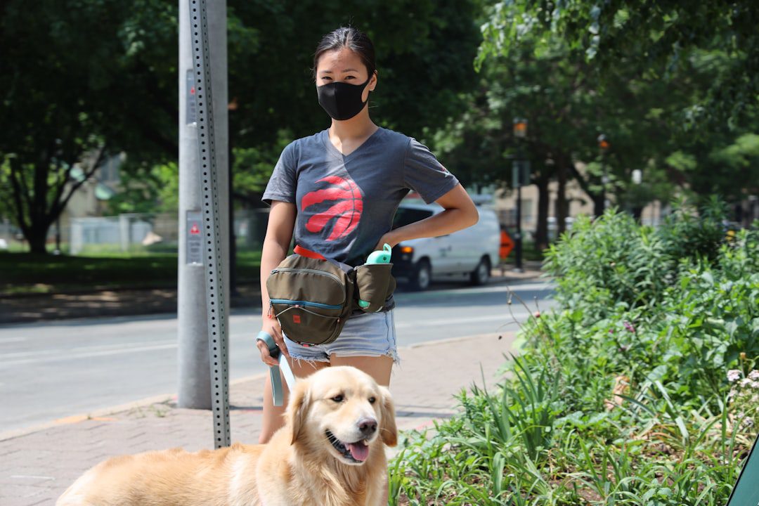 temperament testing — man in blue crew neck t-shirt and black sunglasses sitting beside golden retriever